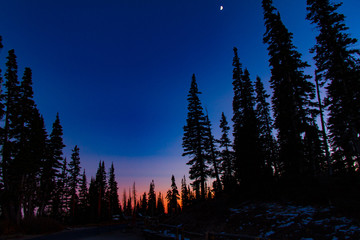 Gorgeous sunset into night sky with moon at Cedar Breaks National Monument in Utah in the winter.