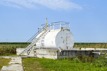 Fototapeta na wymiar Reservoir for sludge of oil emulsion. Equipment at the oil field
