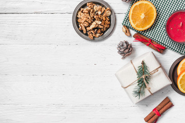 Orange in the cut, cinnamon, walnut on a white background. Branches of Christmas trees, gifts and bumps. A flat place, a place to copy, a top view. Holidays.