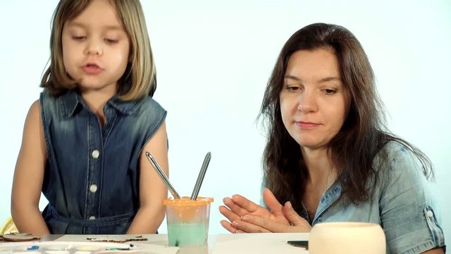 Mom teaches the child the art of painting.