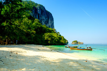Fototapeta premium Concept of travel and relax. Beautiful local fishing boats on sea blue Railay beach, Krabi Thailand