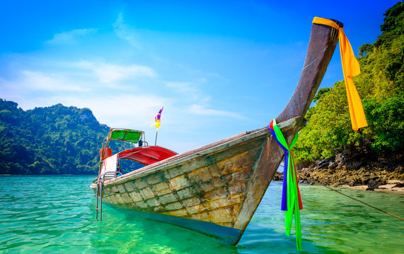 Fototapeta Concept of travel and relax. Beautiful local fishing boats on sea blue Railay beach, Krabi Thailand