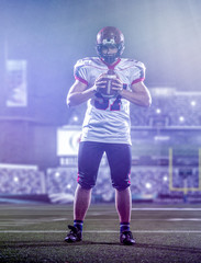 portrait of confident American football player standing on the field