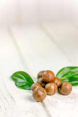 Fresh and ripe macadamia nuts over the wooden table.
