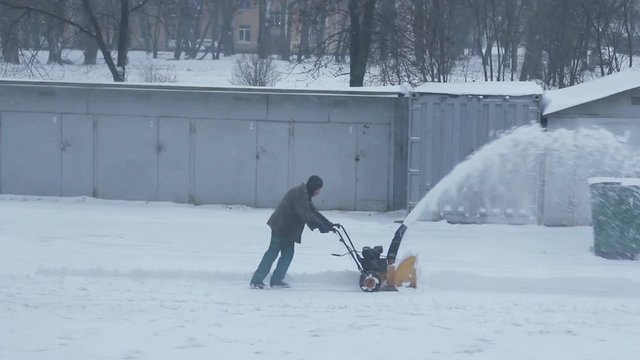 man removes snow with a snow blower, Winter storm