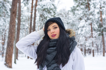 Portrait of a beautiful young woman brunette in a winter park