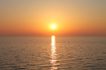 Obraz premium sunset on ocean red orange sinking sun in sea
