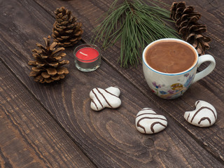 Cup of cocoa with foam and gingerbread on a wooden table