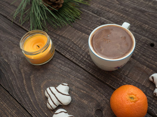 Cup of cocoa with foam and gingerbread on a wooden table