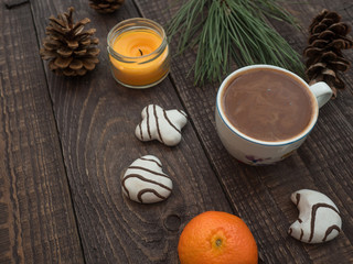 Cup of cocoa with foam and gingerbread on a wooden table