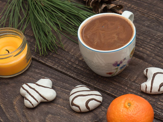Cup of cocoa with foam and gingerbread on a wooden table