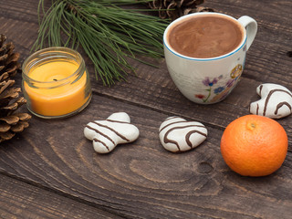 Cup of cocoa with foam and gingerbread on a wooden table