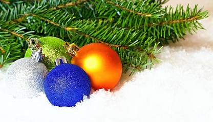 Christmas atmosphere with Christmas balls, spruce branches and snow background. Christmas feelings of harmony, love and calmness. The most Christian holiday.