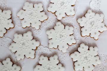 Christmas background. Gingerbread snowflake star cookies set decorated with icing on white table, flat lay. Christmas and New year traditions, winter holidays, homemade sweets, festive food.