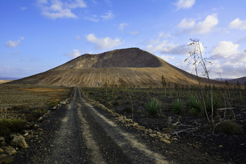 Ein Feldweg der zu einem erloschenen Vulkan hinführt.
