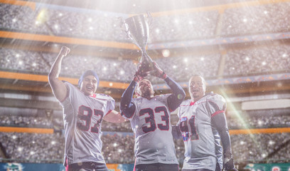 american football team with trophy celebrating victory in the cup final