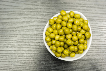 Green peas in a white bowl. View from above.