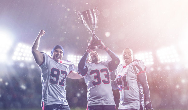 american football team with trophy celebrating victory in the cup final