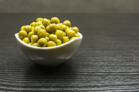 Green peas in a white bowl.