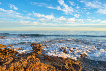 The calm sea in a very cloudy sunset