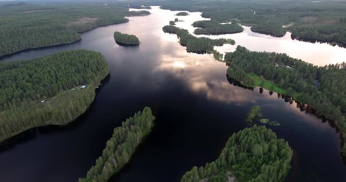 Flying over Finland lakes by sunset