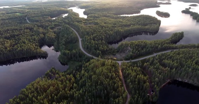 Flying over Finland lakes and forests by sunset