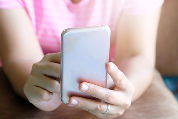 Close up woman hands holding using cell phone for online shopping on sofa in the living room of the house.