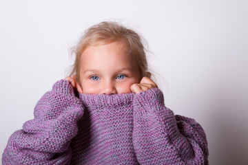happy beautiful little girl wore a knitted lilac mom's sweater