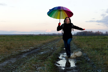 Young emotional woman with an umbrella on a walk, nature light