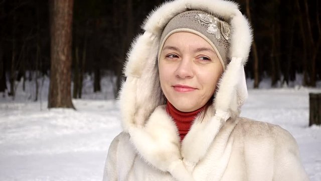 Woman in a mink coat in the forest.