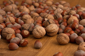 walnuts and hazelnuts scattered on  dark boards, background