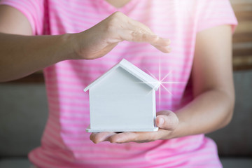 Woman hands presenting a house. Real estate agent offer house. Property insurance and security...