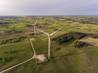 Aerial view over wind turbine in the green valley near Seiriijai village, Lithuania. During cloudy summer day.