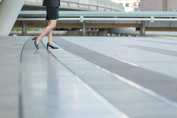 Businesswoman walking away low angle cross section in city.