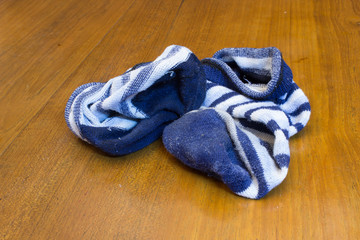Fototapeta na wymiar Dirty Blue Stripes Socks Left on Wooden Floor.