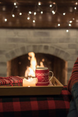 Cozy hot drink in sweater mug by the fire in wintertime