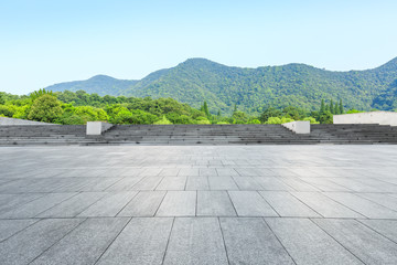 empty square floor and green mountain nature landscape in city park