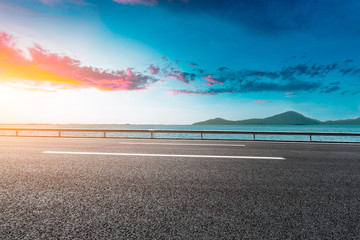 empty asphalt highway and blue sea nature landscape at sunset