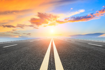 empty asphalt highway and blue sea nature landscape at sunset