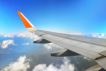 Airplane wing with cloud sky