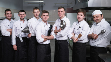 Casting process to find the best for a cooking competition. Male cooks stand confident with kitchen utensils in their arms. Dream of being a chef comes true