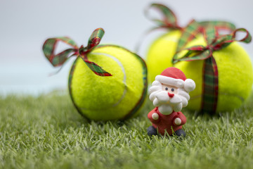 Merry Christmas to Tennis player with Tennis ball and Christmas ornament on green grass