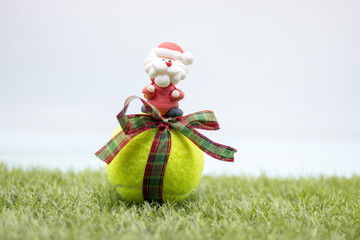 Merry Christmas to Tennis player with Tennis ball and Christmas ornament on green grass