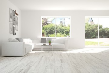 Fototapeta premium Idea of white room with sofa and summer landscape in window. Scandinavian interior design. 3D illustration
