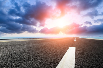 empty asphalt highway and blue sea nature landscape at sunset