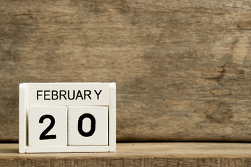 White block calendar present date 20 and month February on wood background
