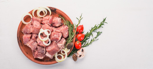 Raw meat is cooked for shish kebab on a wooden background. On the plate Top view. Free space for text.