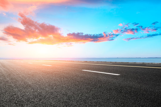 empty asphalt highway and blue sea nature landscape at sunset