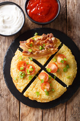 potato pancakes with bacon, tomatoes, onions and sauces close-up. Vertical top view