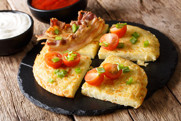 Potato Boxty with bacon, tomatoes, onions and sauce close-up. horizontal
